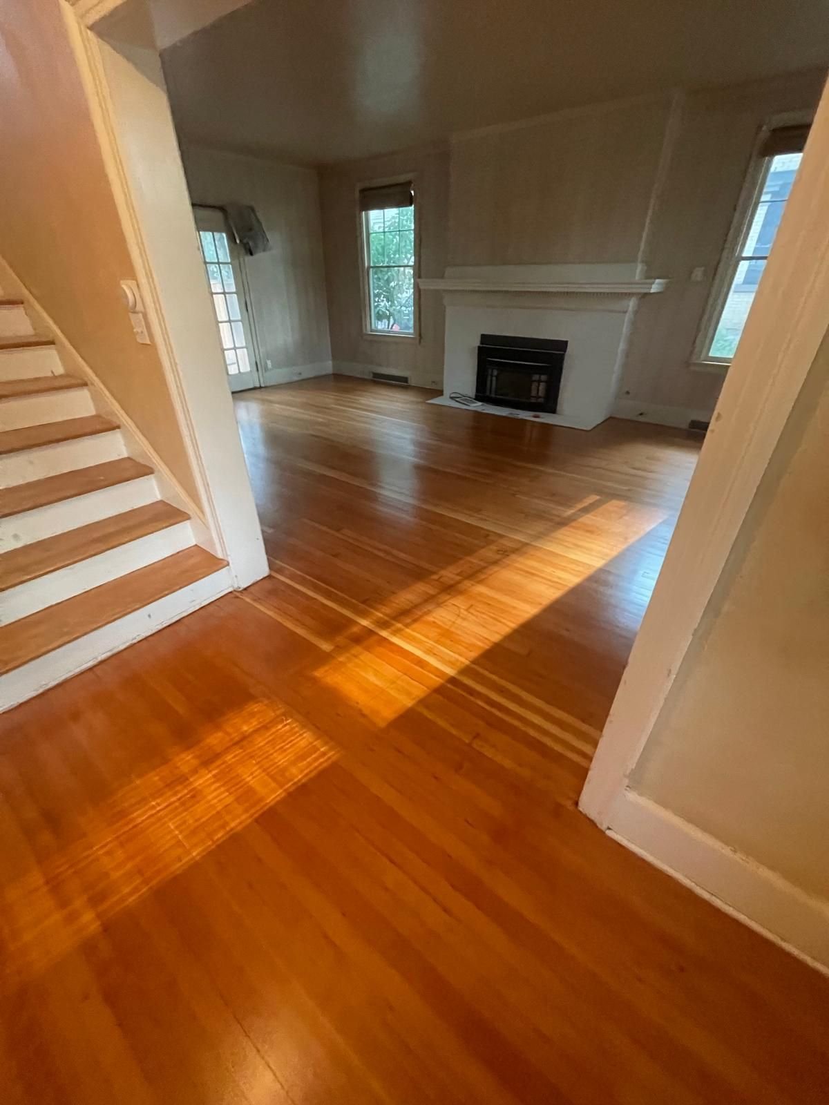 Historic plank floor taken back to sound wood and refinished, running from the stair hall into the living room